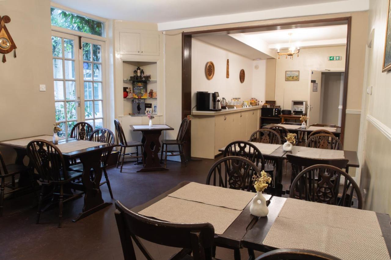 a restaurant with tables and chairs and a kitchen at 72QT in London