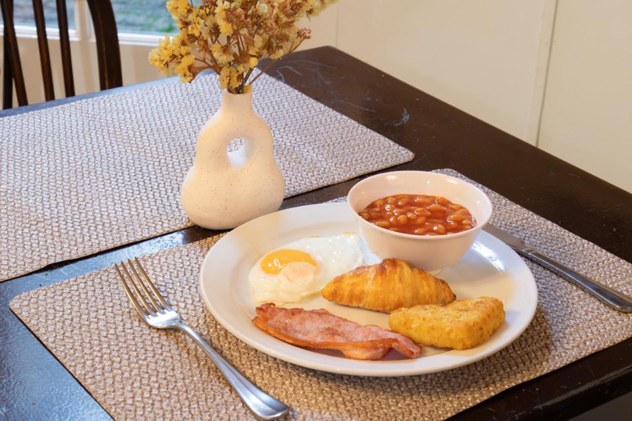 a plate of breakfast food with eggs bacon and beans at 72QT in London