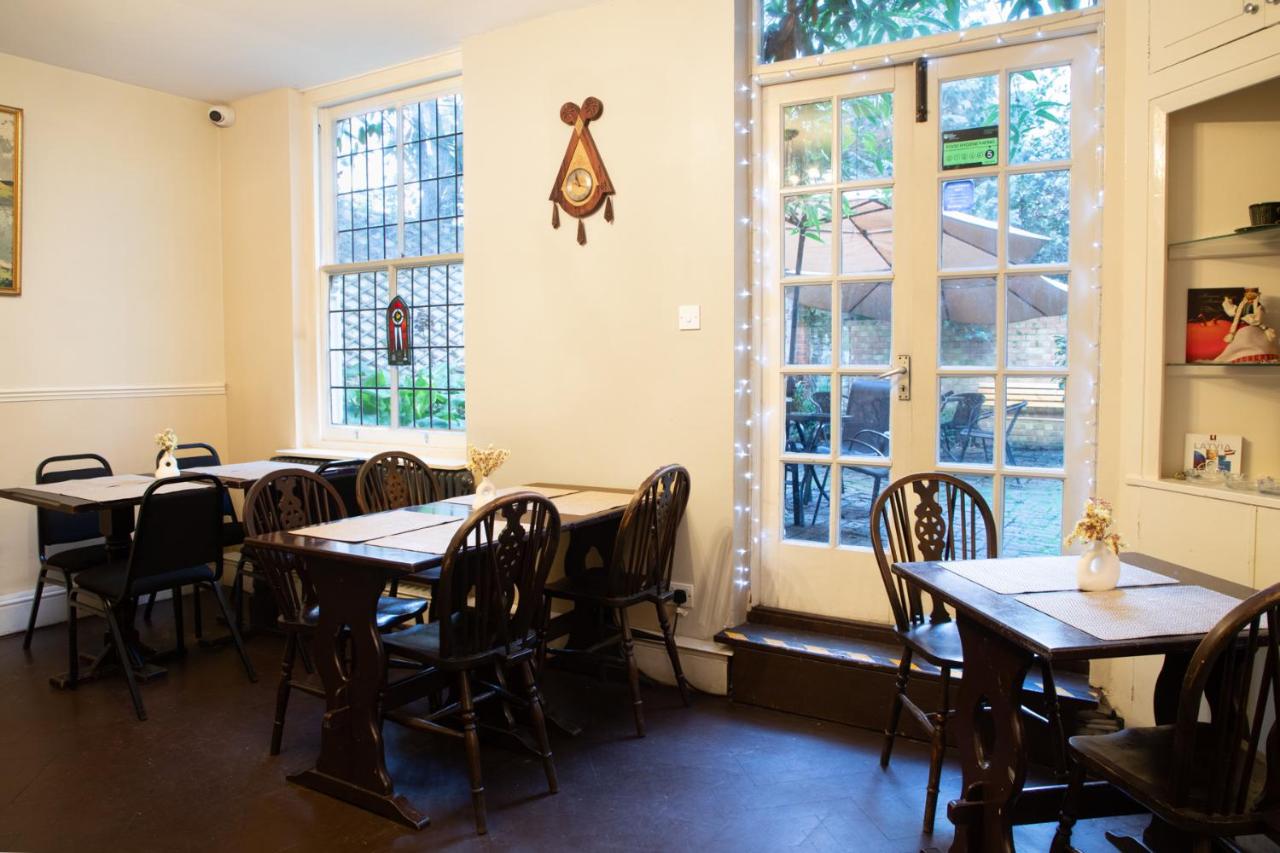 a row of tables and chairs in a room with windows at 72QT in London