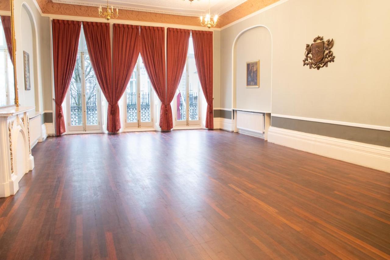 an empty room with red curtains and a hard wood floor at 72QT in London